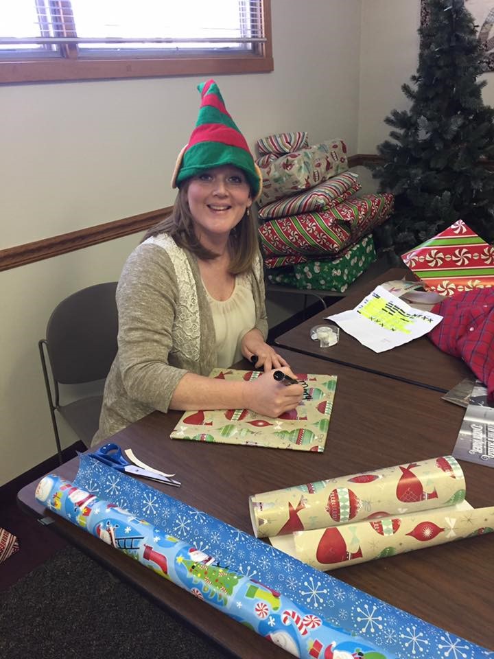 Volunteer in elf hat helping wrap gifts and organize a 5K Run/Walk