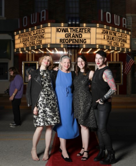 Marianne and Rebecca smiling directly into the camera in front of the Winterset Iowa Theater.