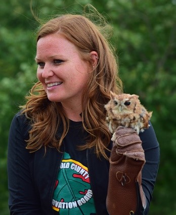 Kate smiling while holding an owl on her gloved hand.