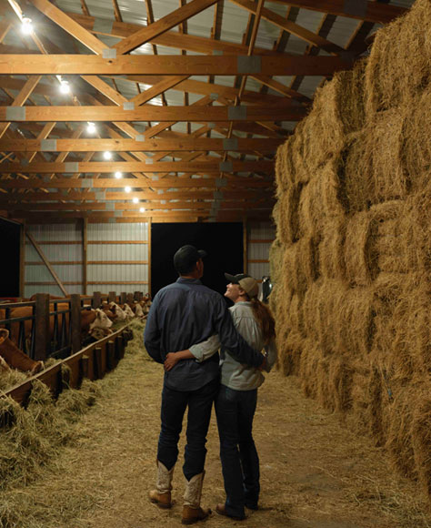 Amanda and husband walking through a barn.