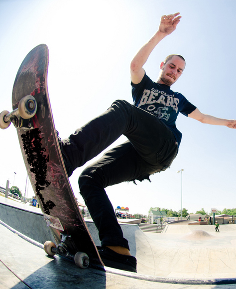Man in a skatepark doing a skateboard trick
