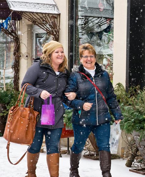 Two women smiling while walking in the snow