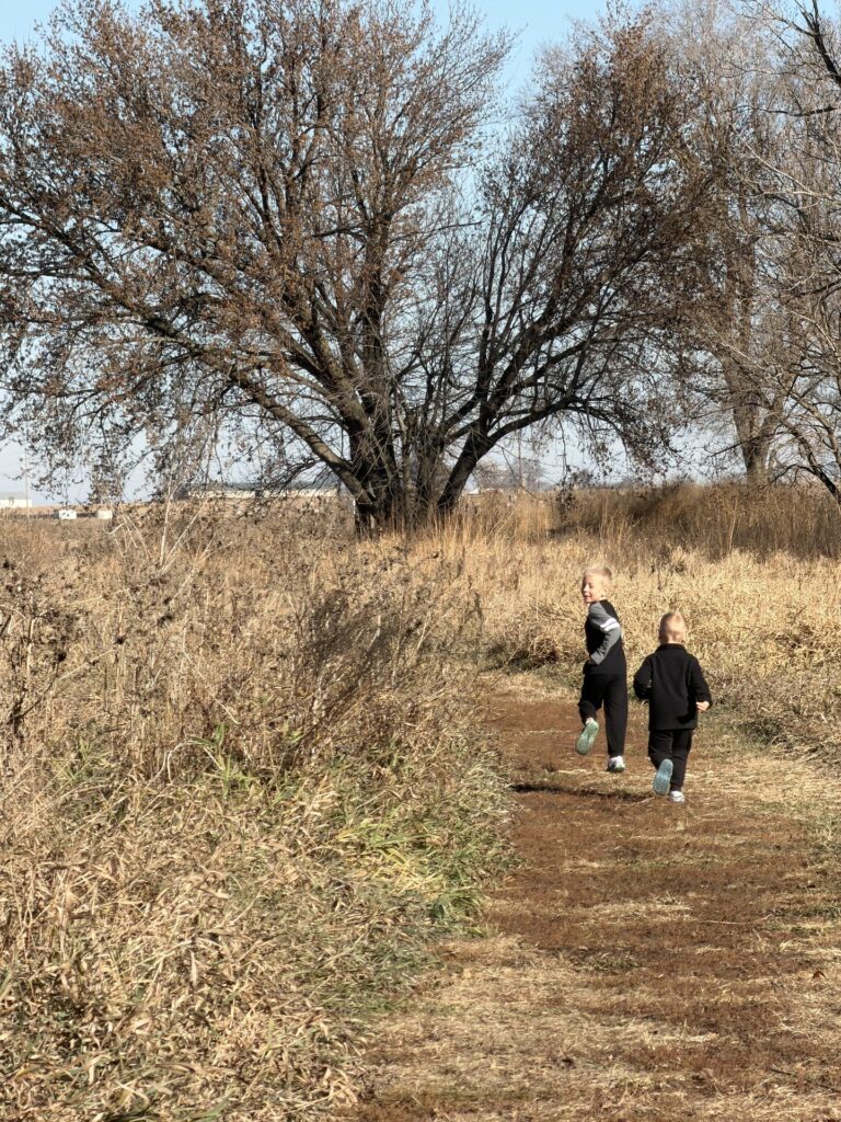 two boys running on a trail in Iowa