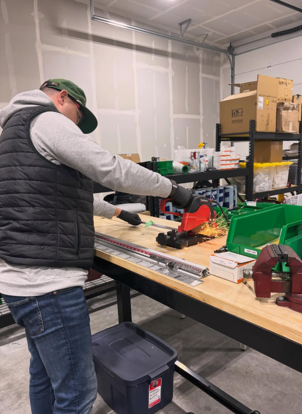 man at a workstation building a golf putter