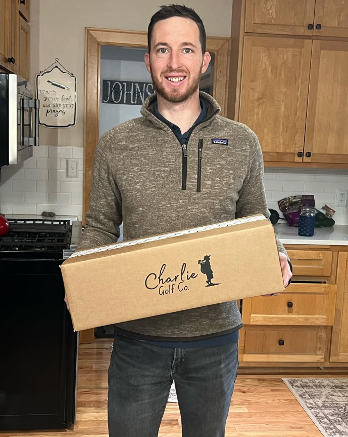 Tyler Johnson holding a Charlie Golf Co bag